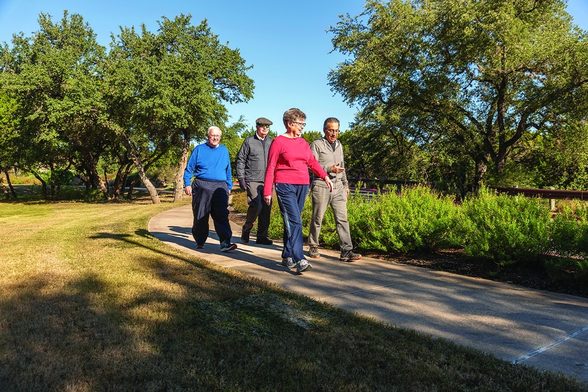 senior friends walk a path at Longhorn Village