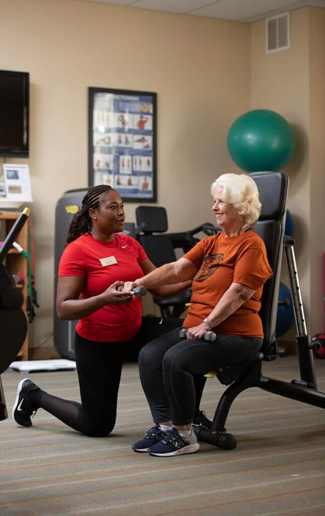 elderly woman receiving assistance with a workout