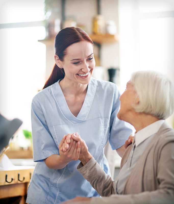 Enjoying work. Beaming caregiver enjoying her work while communicating with pensioner