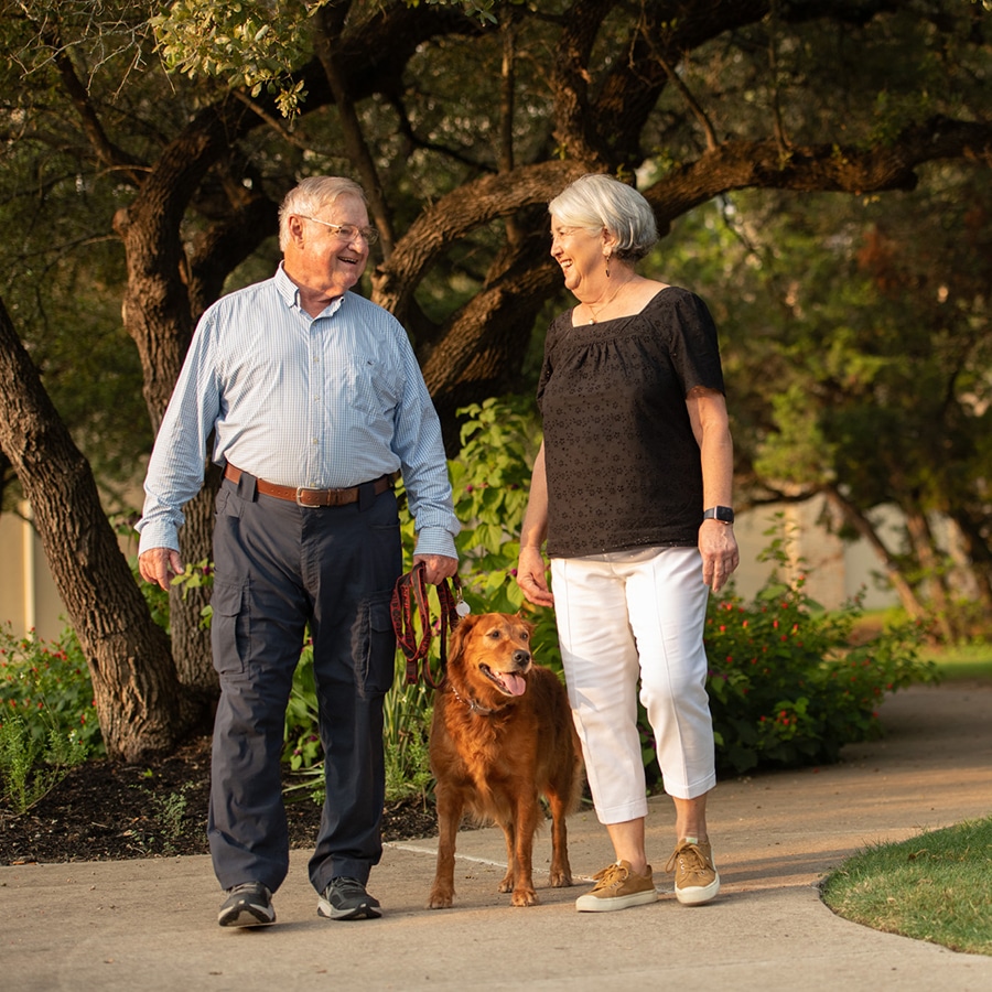 senior couple walking their dog