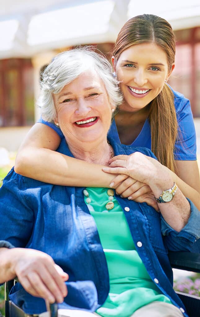 Shot of a resident and a nurse outside in the retirement home garden.