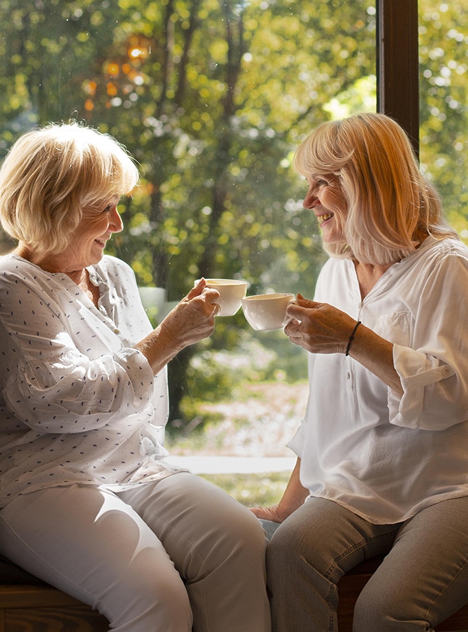 two elderly women enjoying a cup of tea together