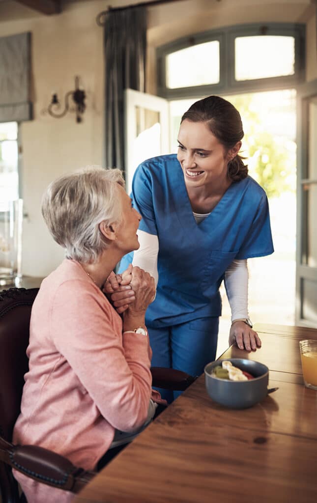 Shot of a young nurse checking up on a senior woman during breakfast at a nursing home.