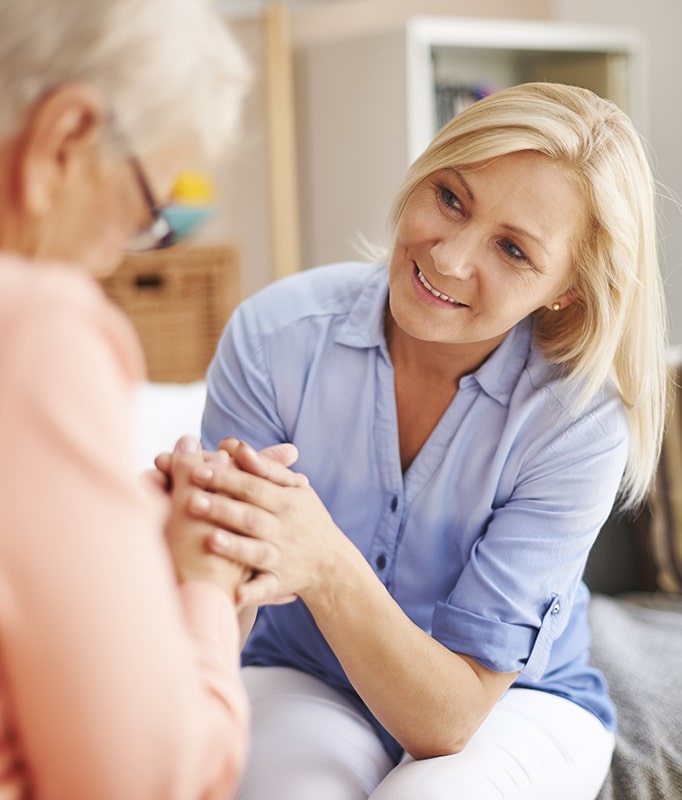 adult daughter taking care of elderly mom