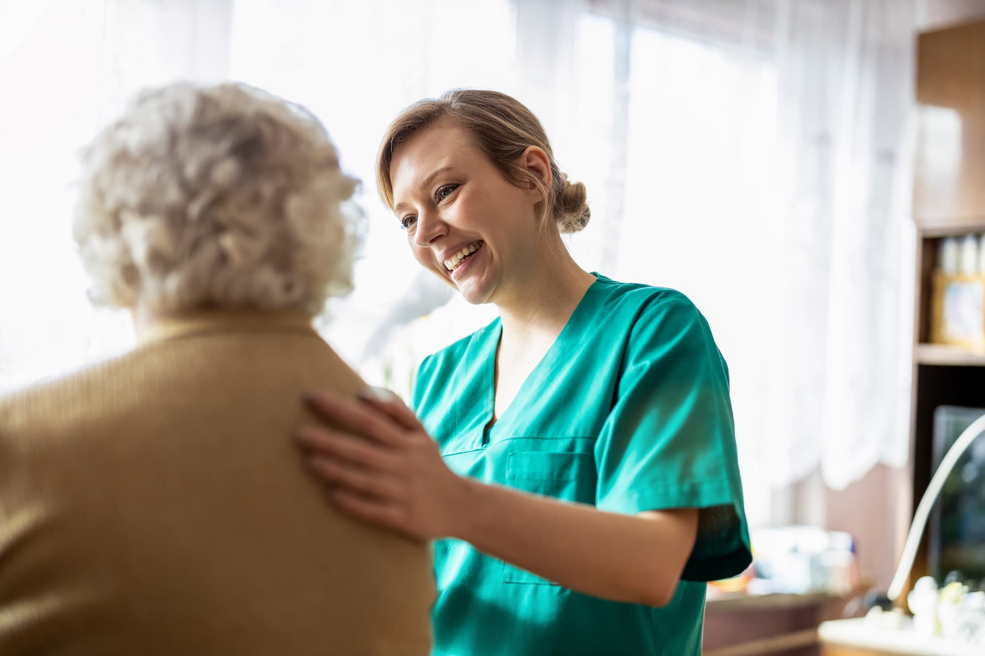 elderly woman receiving care from female nurse