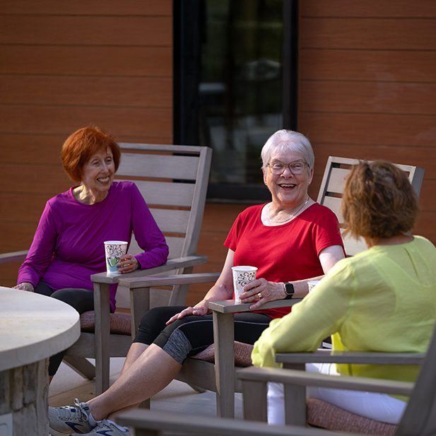 three elderly women enjoying a drink on the outdoor patio at LHV