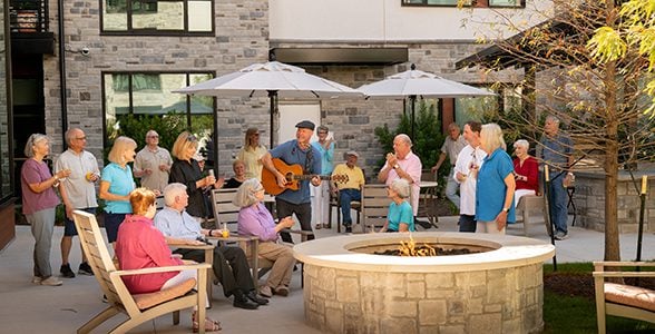 Residents gathered around an outdoor fire pit in the Ballantyne courtyard