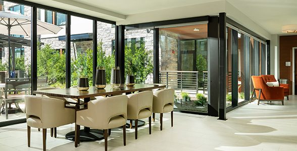 Indoor dining area with a table beside large windows overlooking a patio