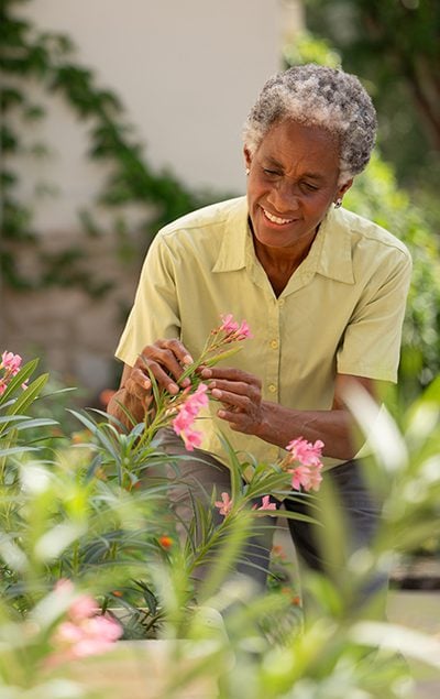 senior man tending to his outdoor garden on-campus