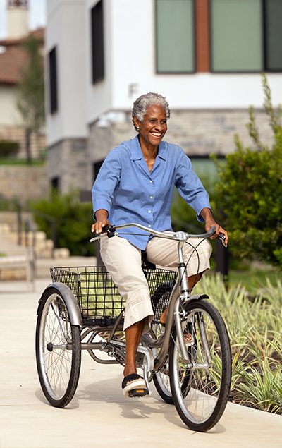 senior woman riding her bicycle around campus