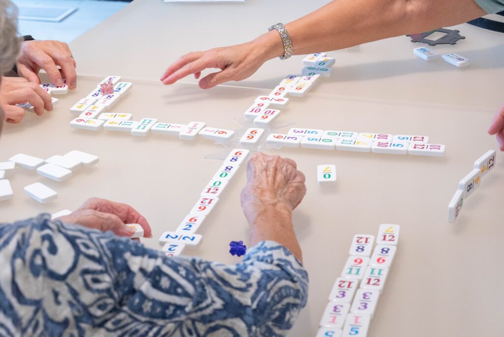 A group of older adult woman playing dominoes 