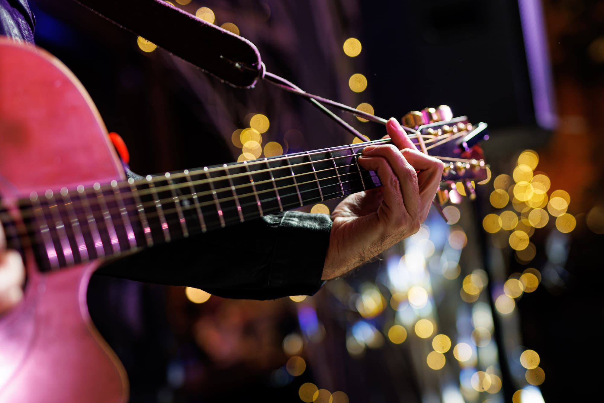 zoomed in photo of a guitar neck being played