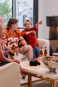 group of seniors cheer on their favorite football team while watching the game on TV