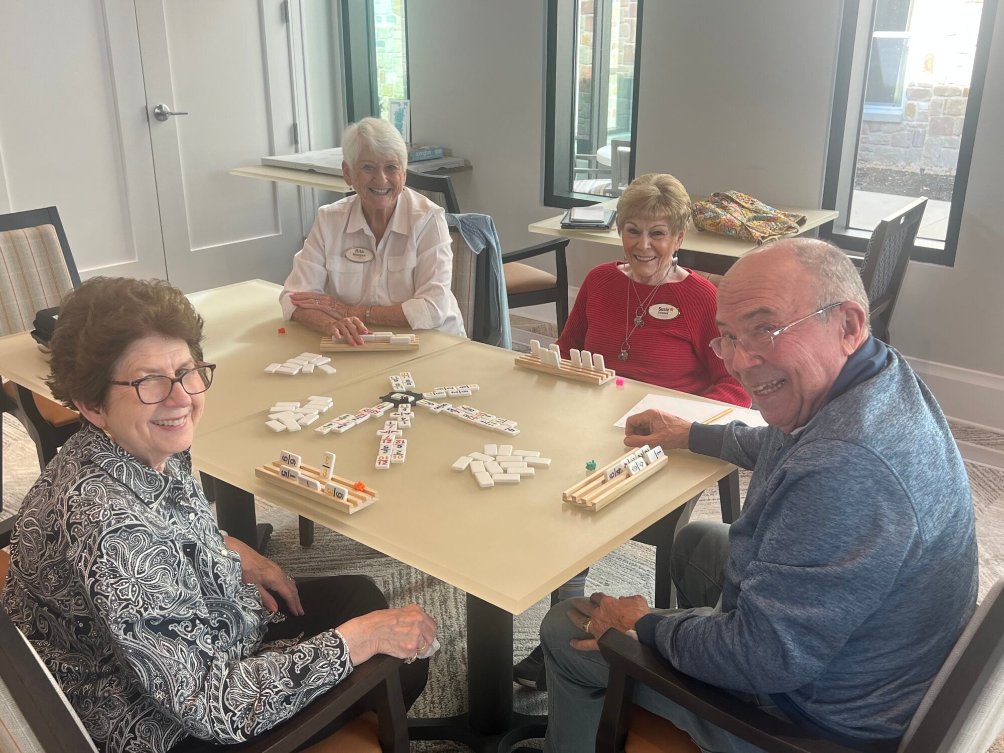 group of seniors play dominos in the community game room