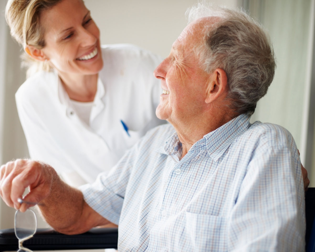 skilled nurse and senior man smiling