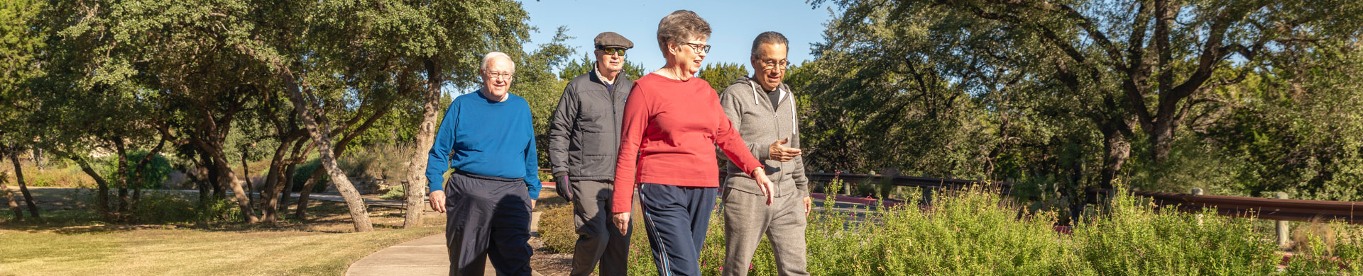 Extended view of seniors walking and talking on path